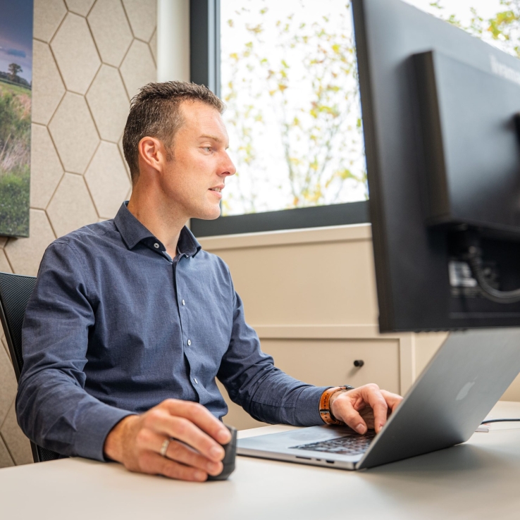 Medewerker Van Voorst Consult achter zijn bureau